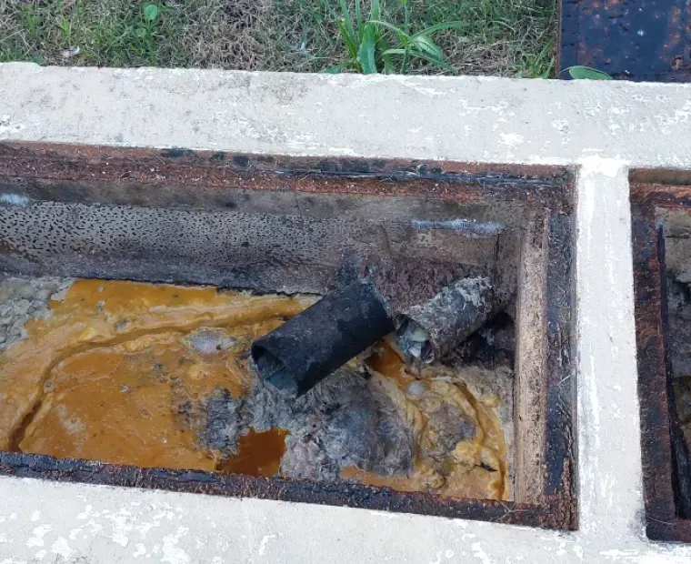Caixa de gordura aberta para limpeza, com resíduo de gordura acumulado